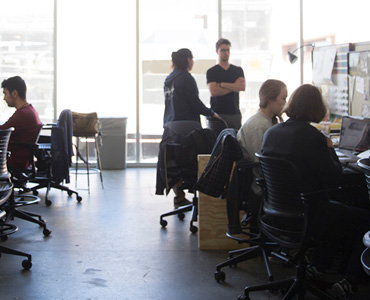 several students sitting in office chairs doing research